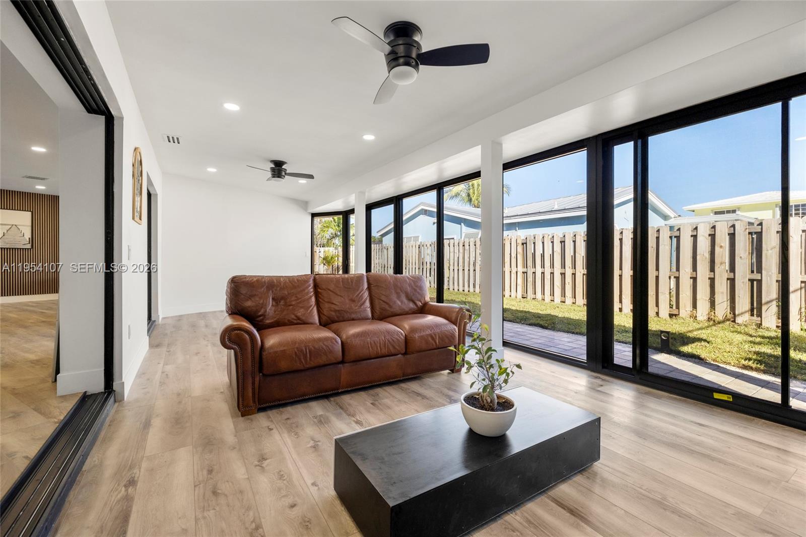 3910 Northeast 27th Terrace Lighthouse Point, FL 33064 - Photo 45 of 55 a living room with furniture and a floor to ceiling window