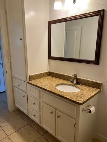 a bathroom with a granite countertop sink and a mirror