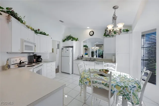 a kitchen with stainless steel appliances kitchen island granite countertop a refrigerator a stove a sink dishwasher and a dining table with wooden floor