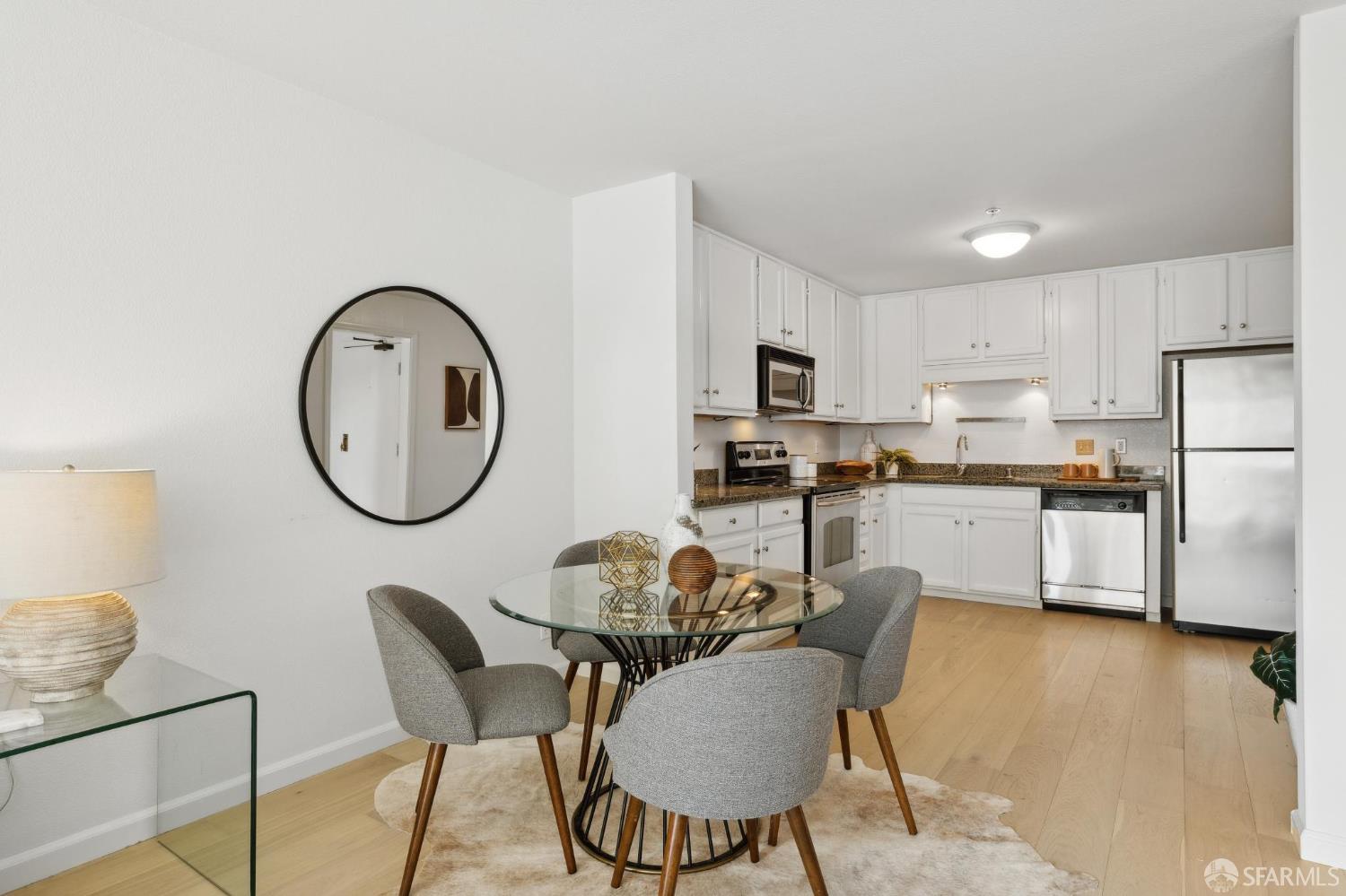 550 South Van Ness Avenue, Unit 207 San Francisco, CA 94110 - Photo 9 of 22 a kitchen with a dining table chairs and a refrigerator