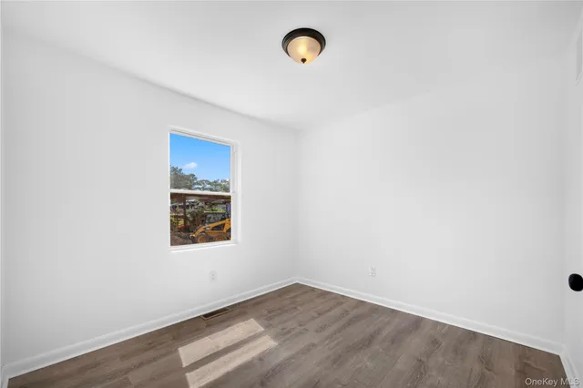 a view of a room with wooden floor and window