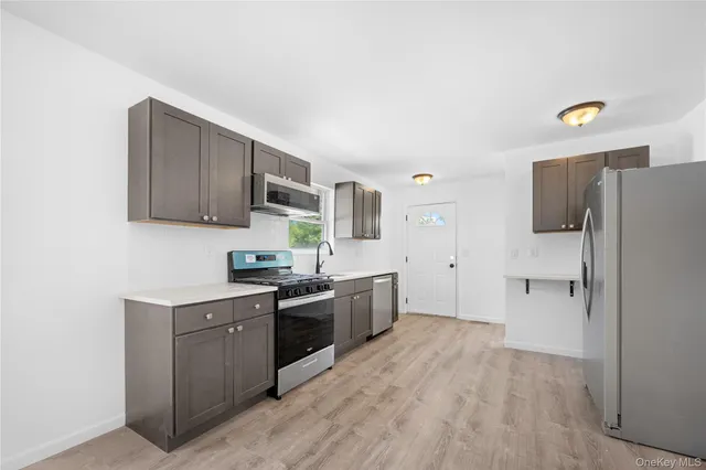 a kitchen with a sink a refrigerator and cabinets