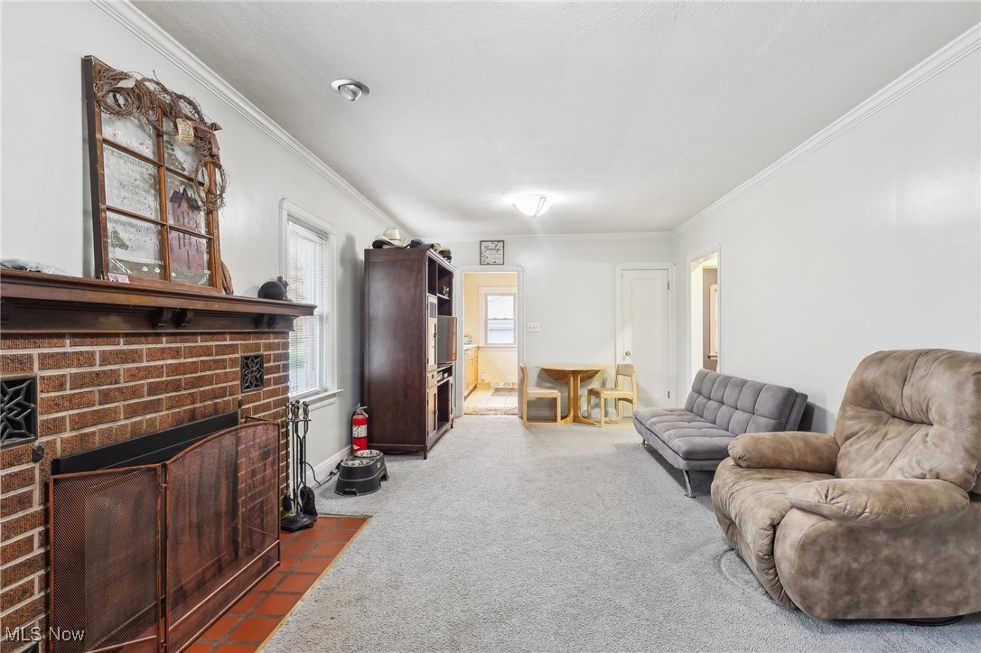 7995 Johnnycake Ridge Road Mentor, OH 44060 - Photo 6 of 47 Carpeted living room with crown molding and a brick fireplace