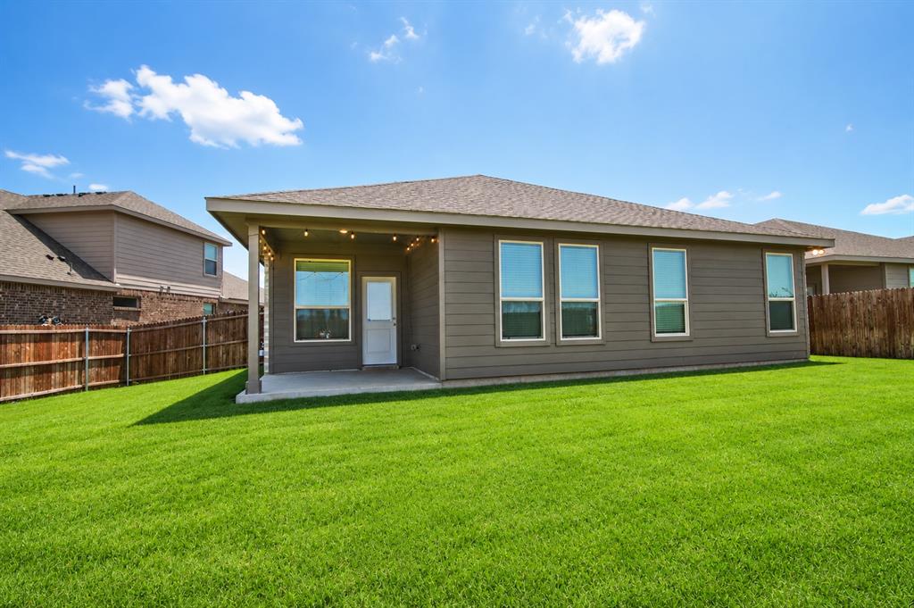 1804 Mensa Drive Haslet, TX 76052 - Photo 25 of 30 Expansive backyard featuring a manicured lawn, a covered patio, and a privacy fence