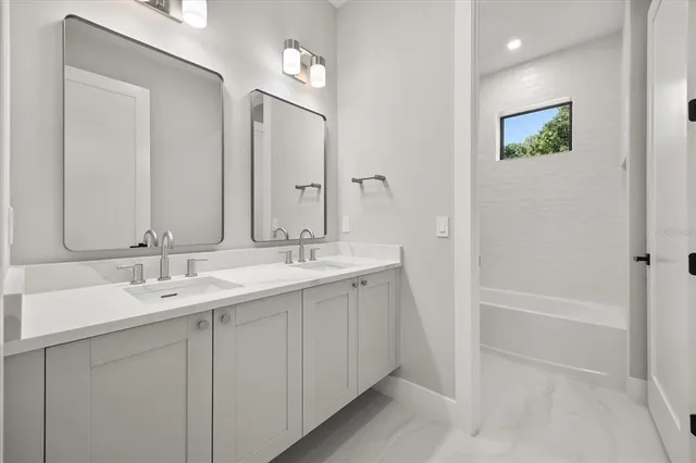 a bathroom with 2 sink tub and a mirror