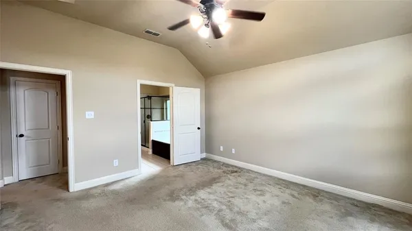 an empty room with closet and a chandelier fan