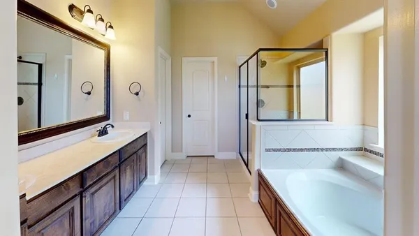 a bathroom with a tub sink and mirror