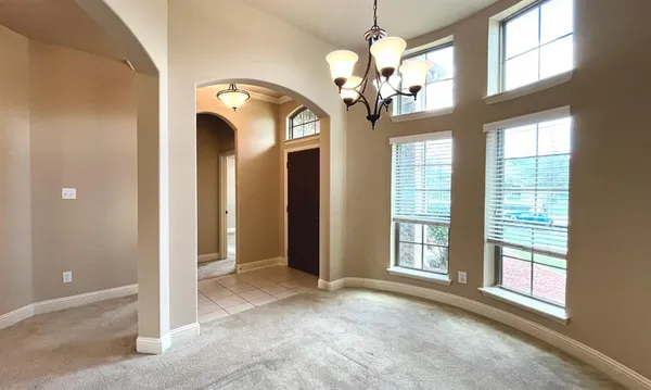 a view of a livingroom with a chandelier fan and windows