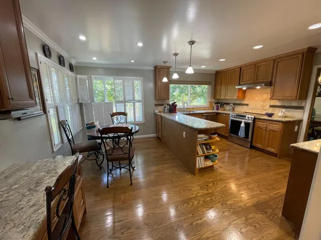 a kitchen with stainless steel appliances granite countertop sink stove top oven and cabinets