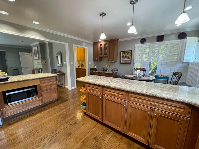 a large kitchen with stainless steel appliances granite countertop a stove a sink and a wooden floors