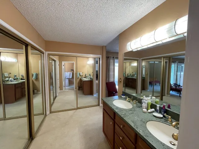 a bathroom with a granite countertop sink mirror and shower