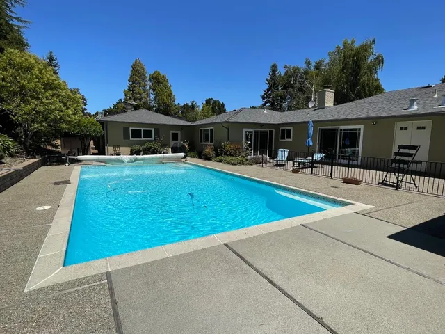 a view of a house with swimming pool and sitting area