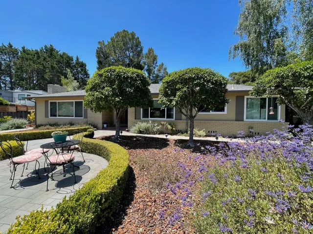 a view of a house with backyard and sitting area