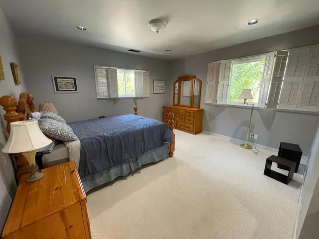 a bedroom with a bed and a large window
