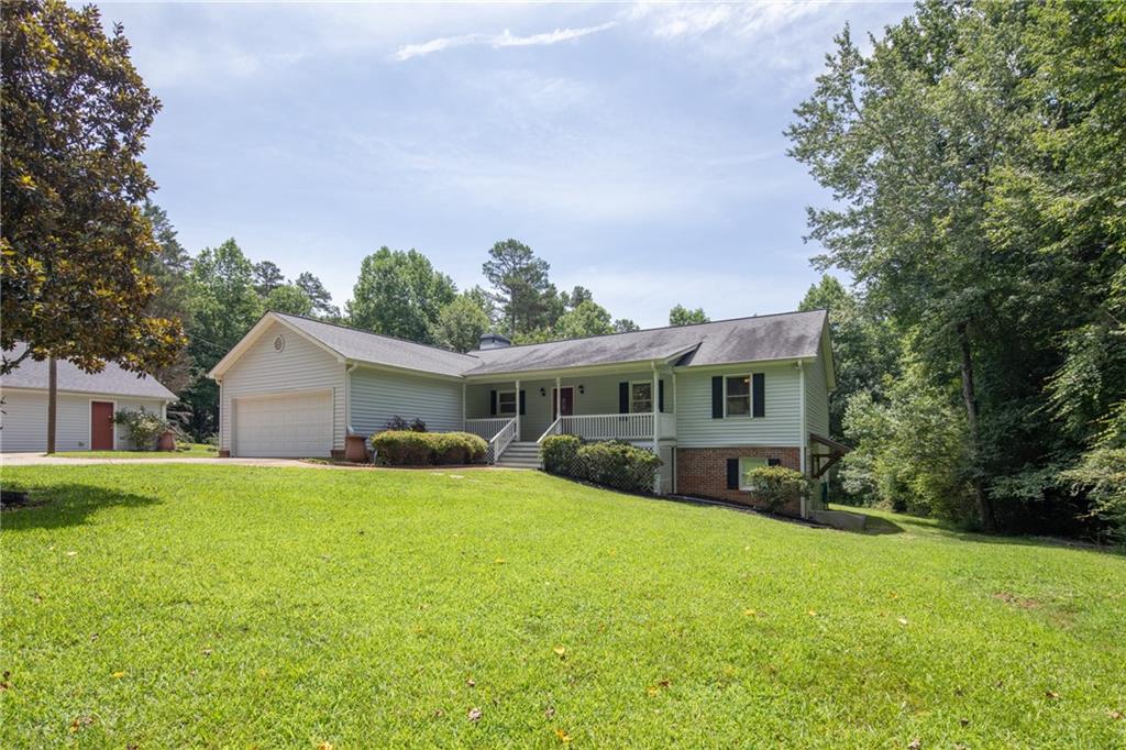 a front view of a house with a yard and trees