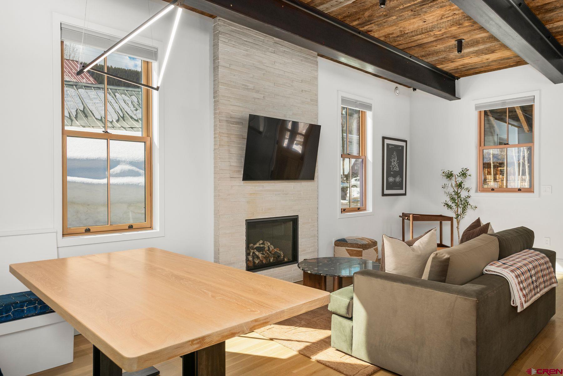 304 2nd Street Crested Butte, CO 81224 - Photo 10 of 37 a living room with furniture a flat screen tv and a fireplace