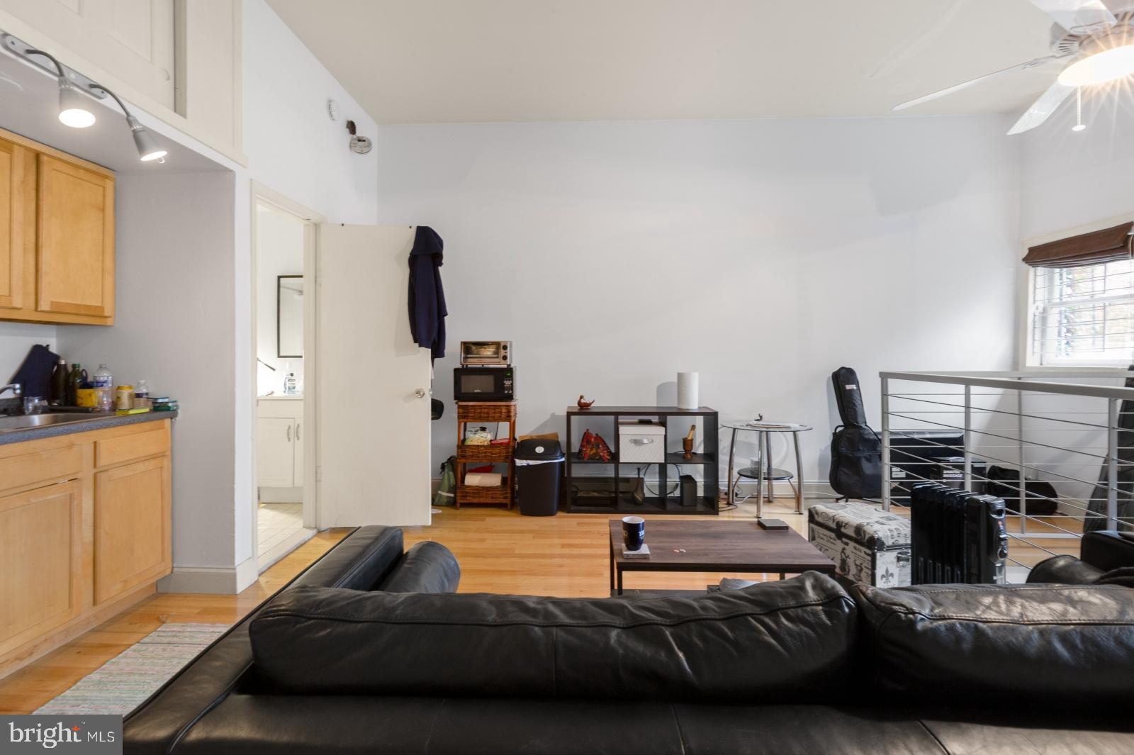 a bedroom with a bed a couch and large window