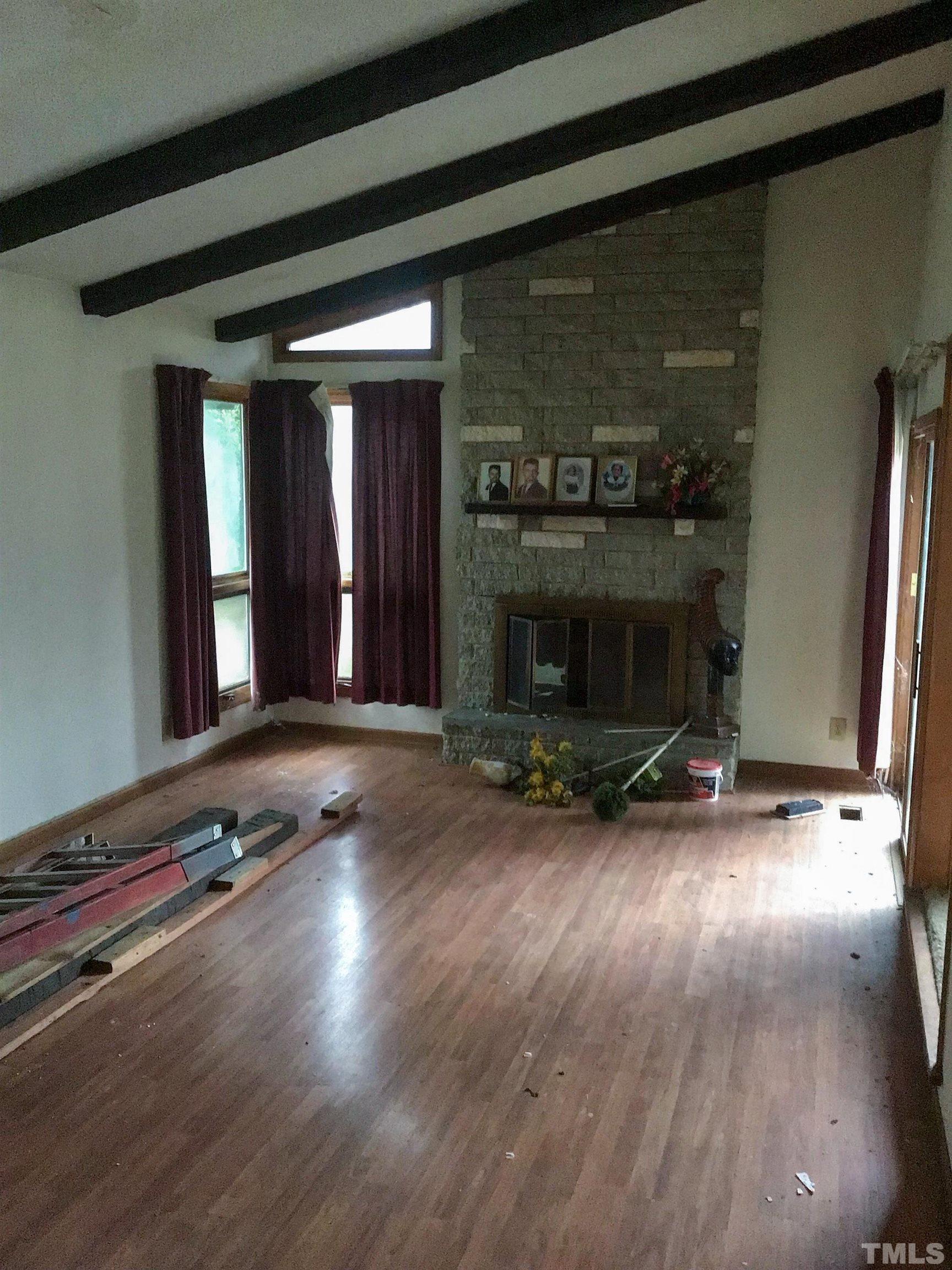 610 Flemingtown Road Henderson, NC 27537 - Photo 8 of 14 an empty room with wooden floor and fireplace
