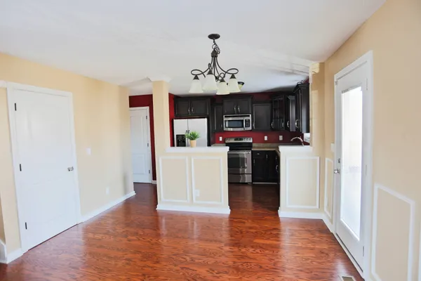 a view of a kitchen with a sink and dishwasher a refrigerator with wooden floor