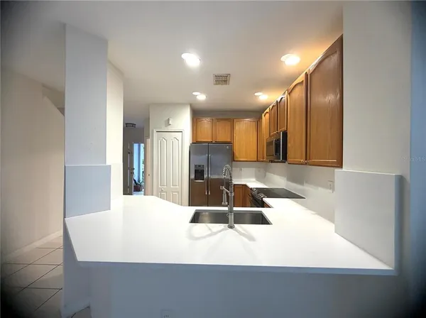 a large white kitchen with a sink and a large mirror