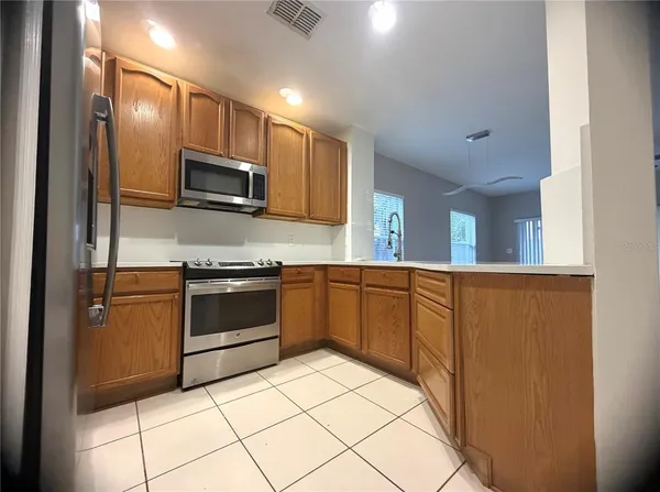 a kitchen with stainless steel appliances a refrigerator sink and microwave
