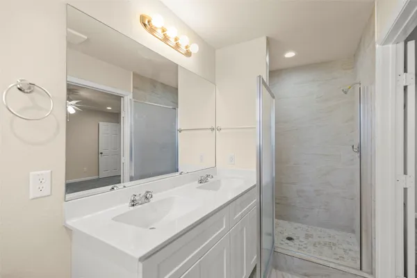 a bathroom with a double vanity sink and a mirror