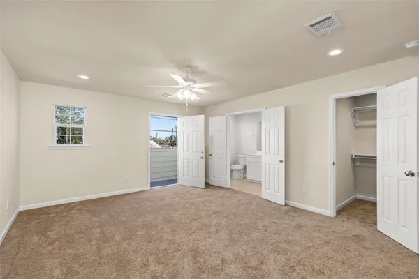 an empty room with windows and bathroom view