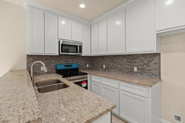 a kitchen with granite countertop cabinets stainless steel appliances and a sink