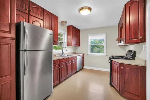 a kitchen with stainless steel appliances granite countertop a refrigerator a sink dishwasher a stove top oven a refrigerator and dishwasher