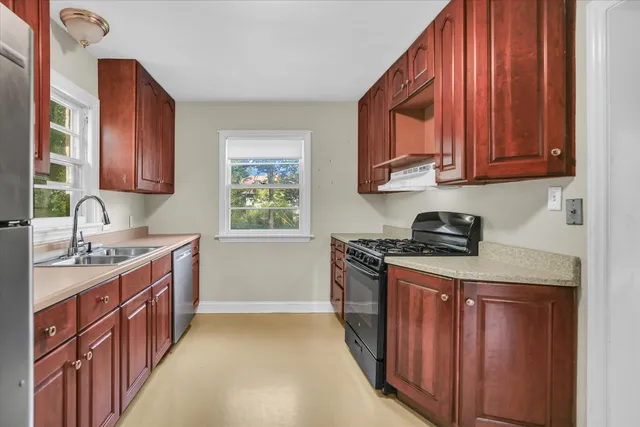 a kitchen with stainless steel appliances granite countertop a stove a sink and a microwave