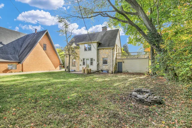 a view of a house with a big yard and large trees