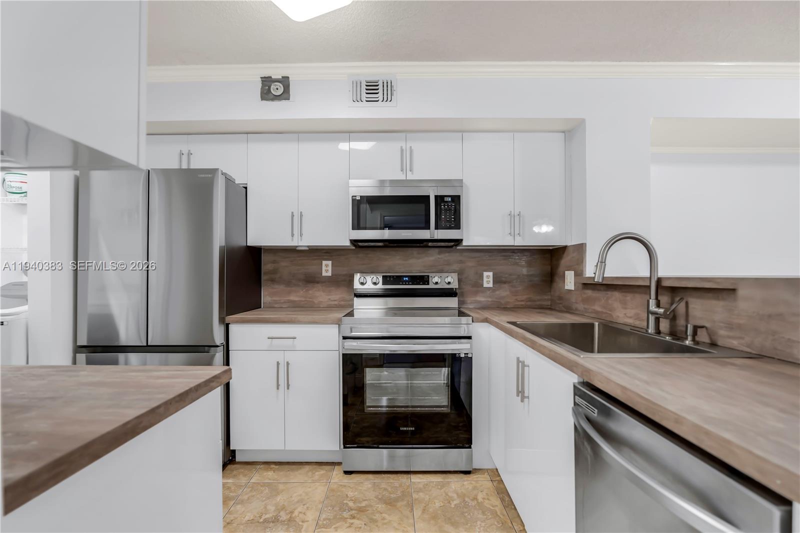 a kitchen with stainless steel appliances granite countertop a stove a sink and a microwave