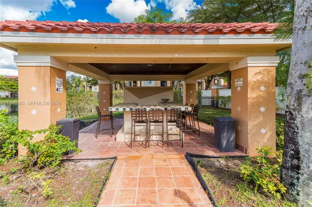 a view of a patio with a table and chairs under an umbrella with a potted plant