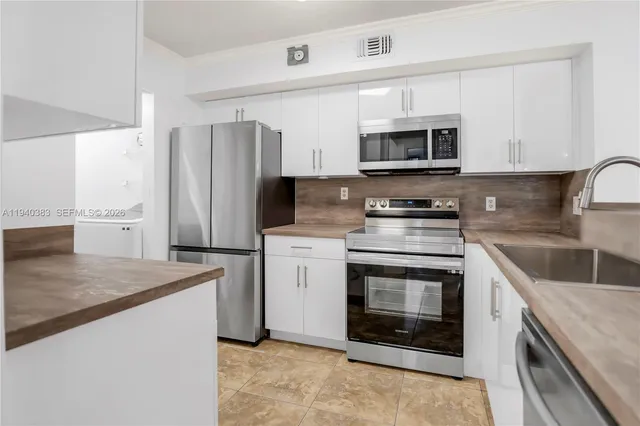 a kitchen with stainless steel appliances granite countertop a stove a refrigerator and a microwave