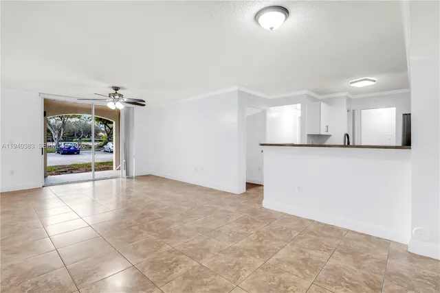 a view of a kitchen with refrigerator and window