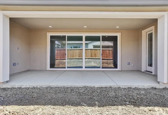 an empty room with floor to ceiling window and an outdoor view