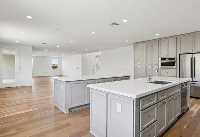 a kitchen with stainless steel appliances granite countertop a sink and dishwasher a stove with wooden floor