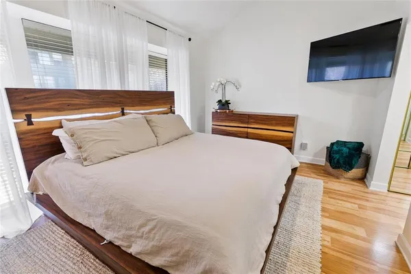 a bedroom with a bed and a flat screen tv