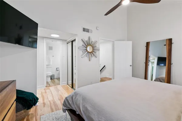 a bedroom with a bed and a flat tv screen on dresser