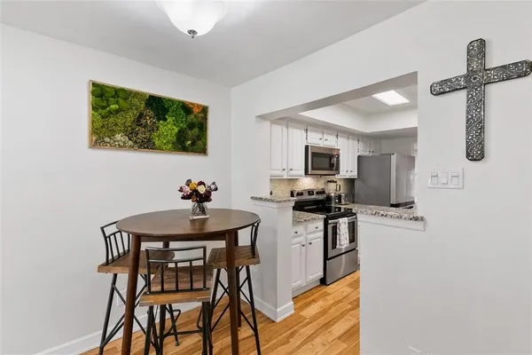 a kitchen with stainless steel appliances kitchen island a table and chairs in it