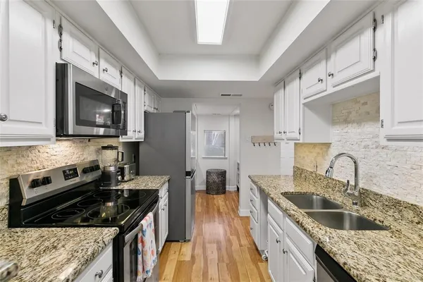 a kitchen with stainless steel appliances granite countertop a sink stove and refrigerator