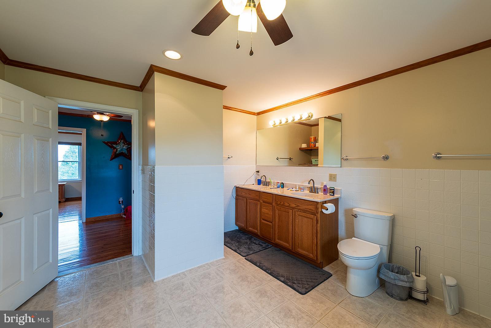 2613 Hoopers Island Road Fishing Creek, MD 21634 - Photo 18 of 54 a bathroom with a granite countertop toilet sink and mirror