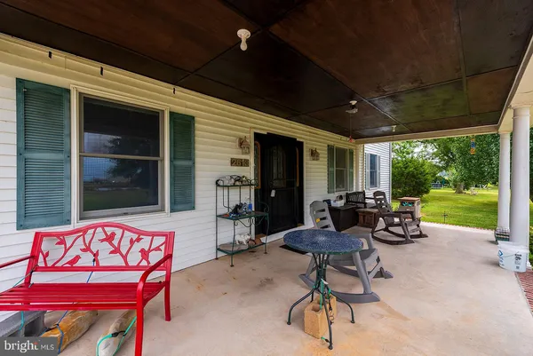 a living room with patio furniture and a garden