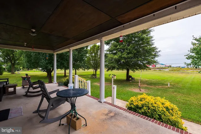 a view of a chairs and table in patio with a yard
