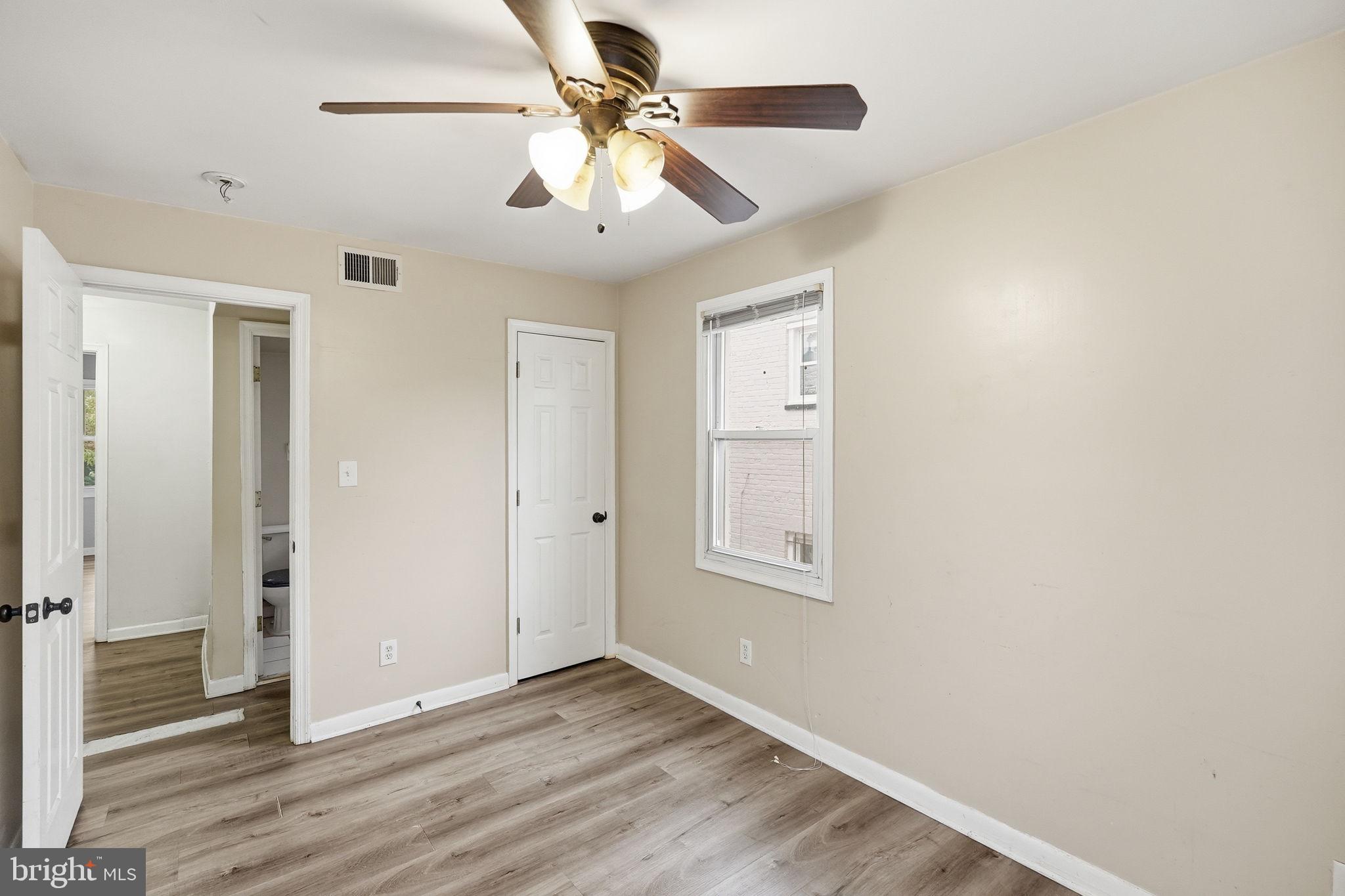 3417 B Street Southeast Washington, DC 20019 - Photo 12 of 22 an empty room with wooden floor fan and windows