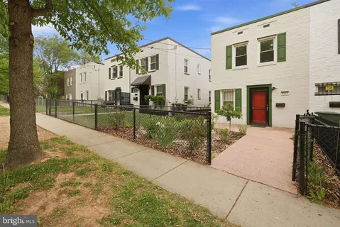a view of a white house with a yard