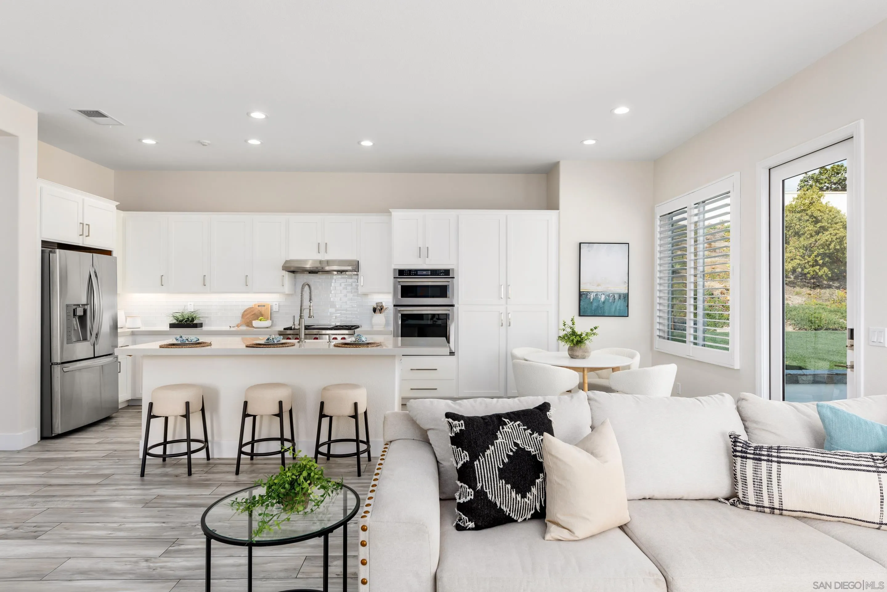 6814 Moorhen Place Carlsbad, CA 92011 - Photo 13 of 37 a living room with stainless steel appliances furniture a rug and a kitchen view