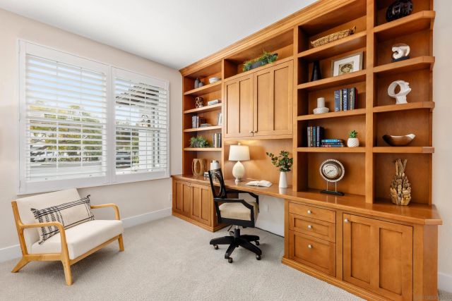 a view of a workspace with furniture and a window