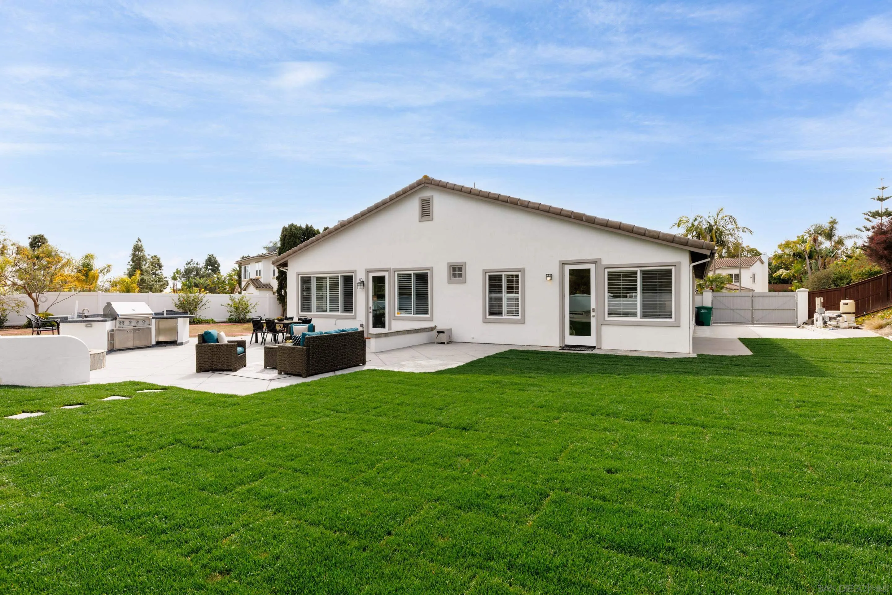 6814 Moorhen Place Carlsbad, CA 92011 - Photo 21 of 37 a big white house with a big yard and large trees