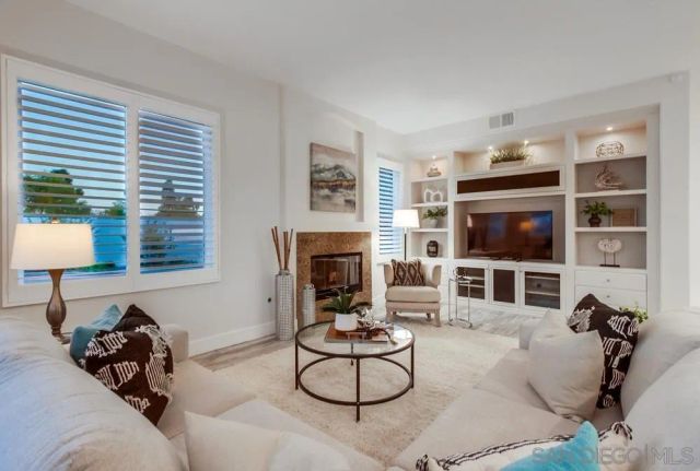 a living room with furniture a flat screen tv and a fireplace